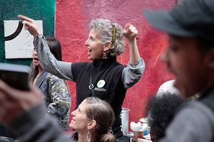 Anne Bluthenthal in crowd with arms raised