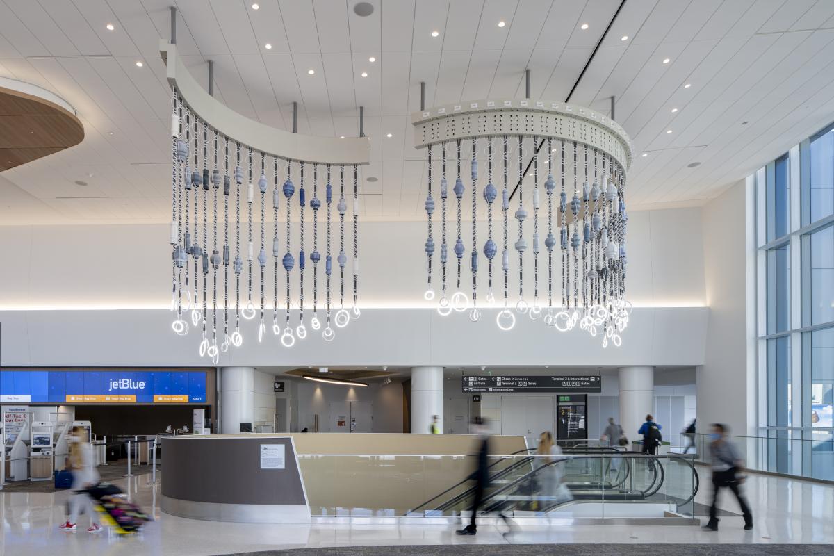 A hanging light installation by Dana Hemenway. Made up of extension cords woven with large ceramic "beads" to resemble macrame, the suspended installation hangs over a stairway at SFO.