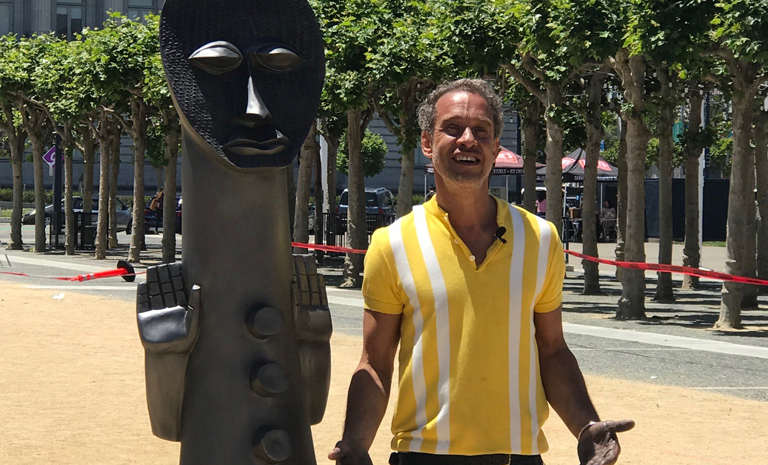 Artist Zak Ove standing next to one of his figures from his installation Invisibel Man and the Masque of Blackness