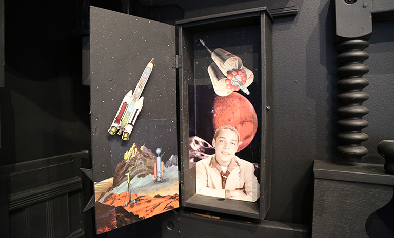 black cabinet with a collage of outer space and a young boy. 