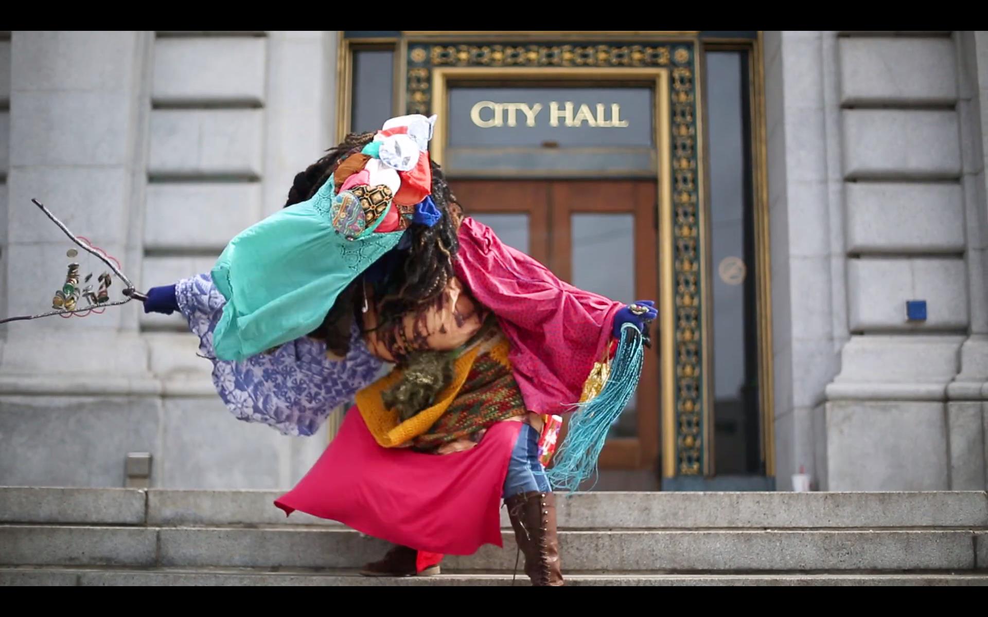 Kenyatta A.C. Hinkle, The Retrieval on view though April 7 image of costumed healer on the steps of City Hall.