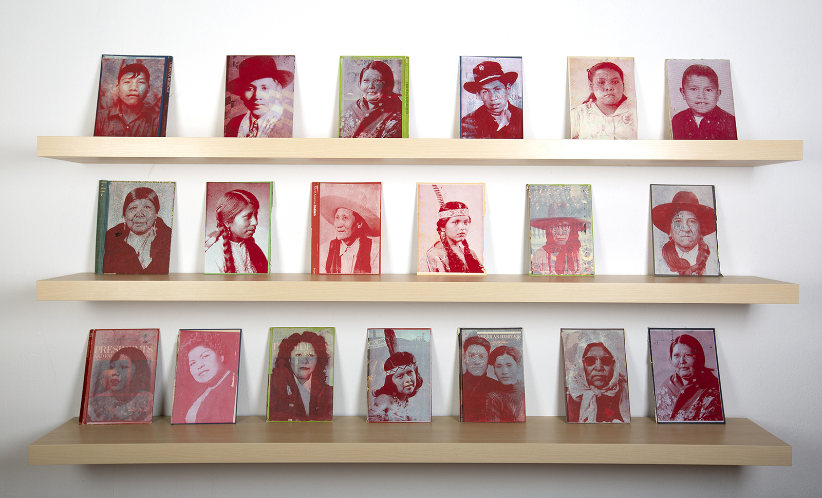 Three shelves with 19 works featuring portraits from an Indigenous family archive screen printed onto book pages