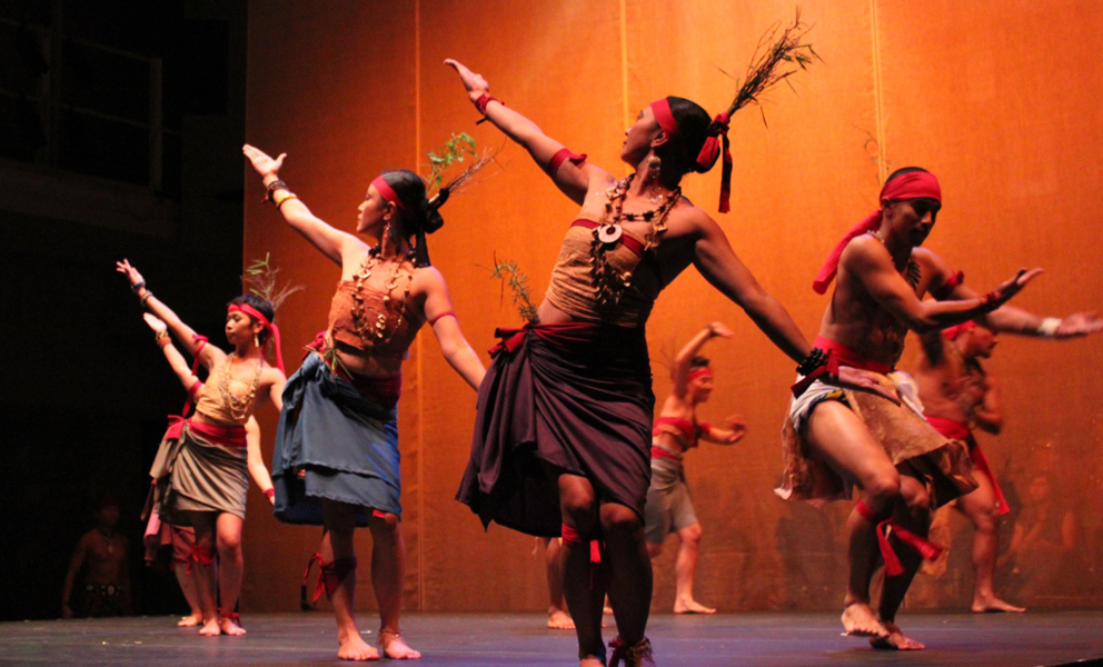 Dancers on a stage with their arms outstreached 