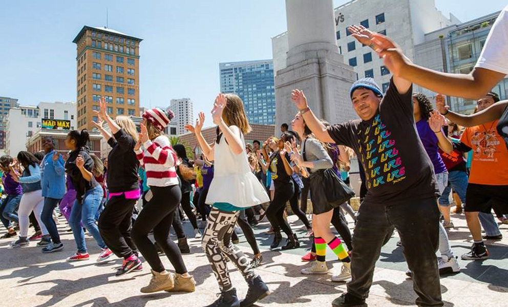 A crowd of people dancing in an oudoor plaza