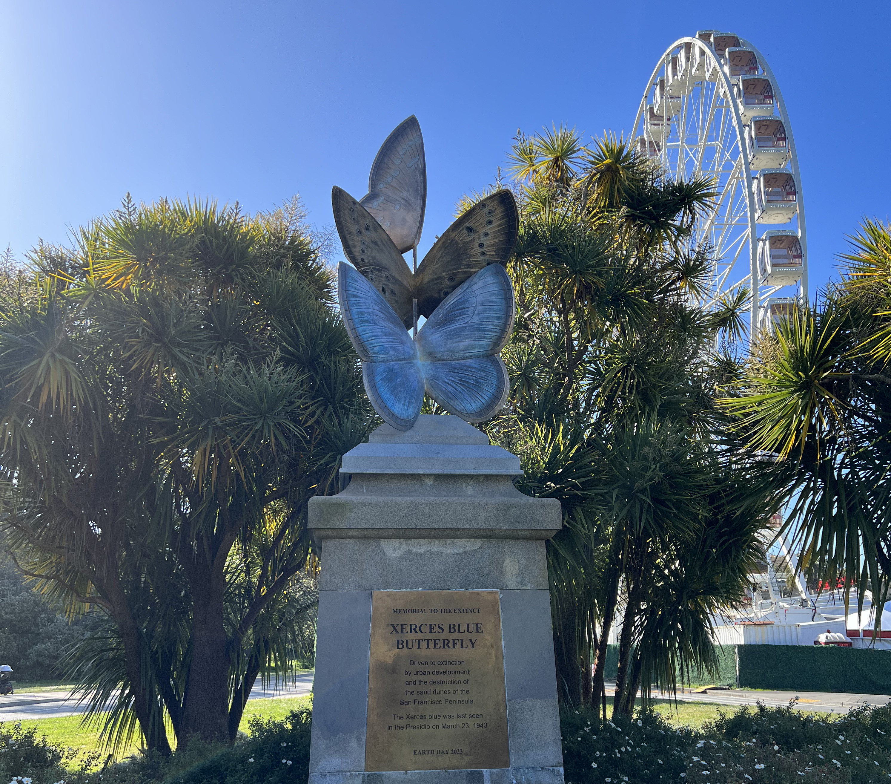 Image of a sculpture of three giant blue butterflies on top of a plinth