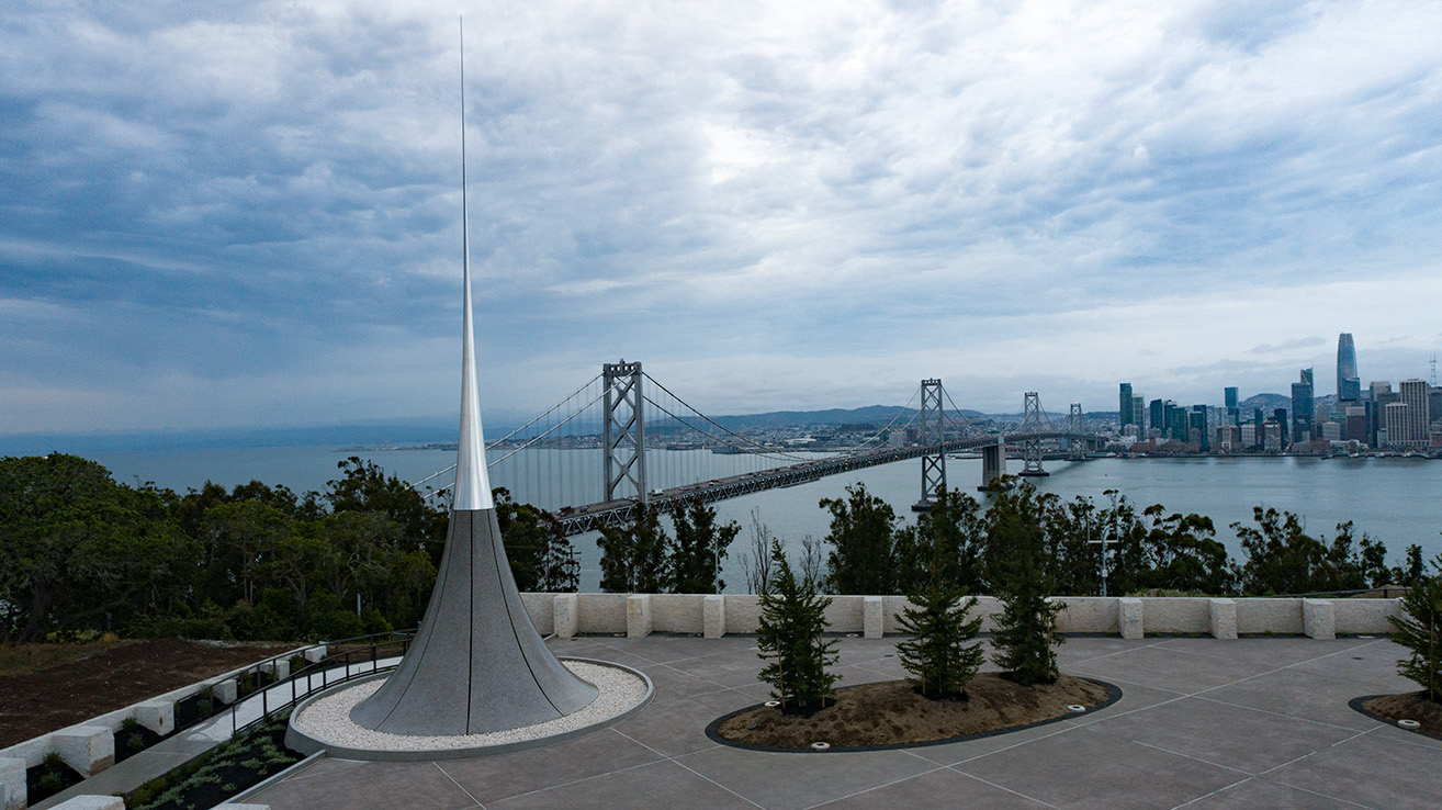 Point of Infinity sculpture in front of a view of the Bay Bridge and San Francisco skyline